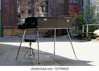 Old Fender Rhodes piano stands out on the street in the backyard of an old industrial complex. This Photo was taken in the summer in Cologne, Germany at Kunstwerk in Deutz.