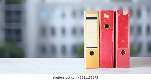 old files,paperwork,ringbinder,file folders,document files, negative space, blurred office building in the back.