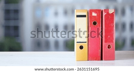 old files,paperwork,ringbinder,file folders,document files, negative space, blurred office building in the back.