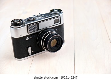 an old film camera on a light wooden background