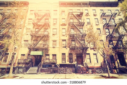 Old Film Retro Style Photo Of New York Building With Fire Escape Ladders, USA.