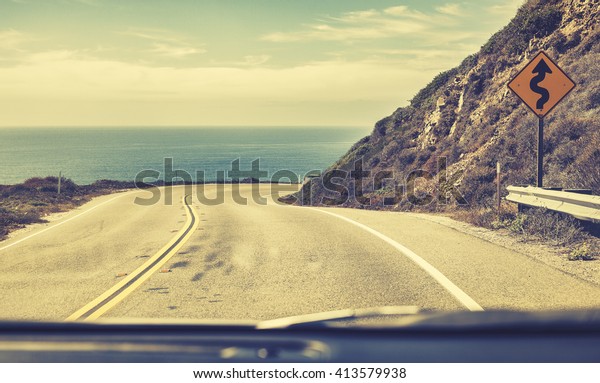 Old film stylized road seen through\
windshield of a car, Pacific Coast Highway,\
USA.