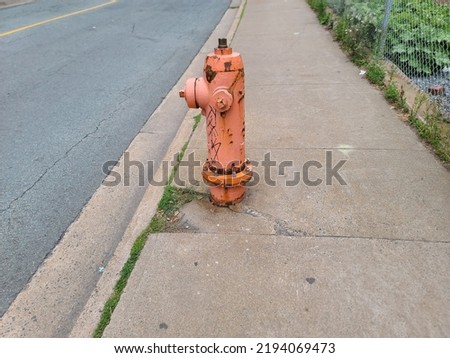 An old fire hydrant that is in need of a paint job as rust is showing through the chipped paint.
