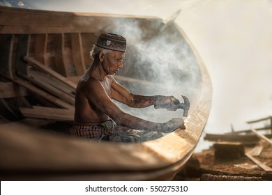 An old fisherman was repairing a ship at Nai Tung Village, Nakhon Si Thammarat, Thailand. - Shutterstock ID 550275310