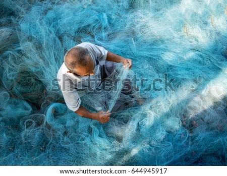 Old Fishermen are repairing fishing nets.Fishermen are cleaning fishing nets.Thailand