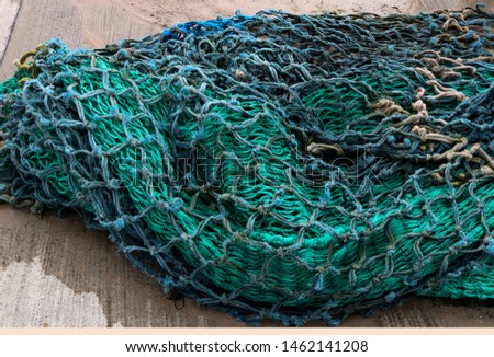 Old fishing nets piled at a coastal harbour 