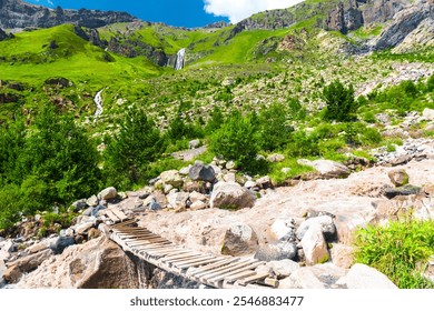 An old, flimsy wooden bridge across a turbulent, full-flowing mountain river with a fast current. Caucasus, Elbrus region. - Powered by Shutterstock