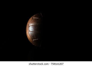 Old Football Leather Ball On A Black Background