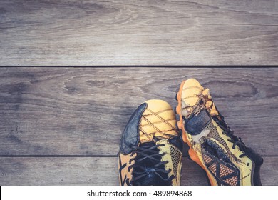 Old football shoes on grey wooden plank background