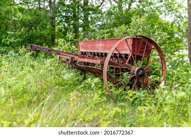 Old Forgotten Rusting Antique Farm Equipment Left In An Overgrown Meadow, Quebec, Canada.