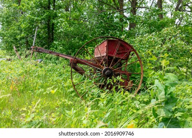 Old Forgotten Rusting Antique Farm Equipment Left In An Overgrown Meadow, Quebec, Canada.