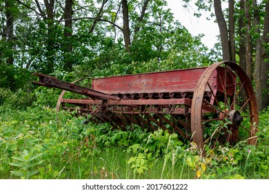 Old Forgotten Rusting Antique Farm Equipment Left In An Overgrown Meadow, Quebec, Canada.