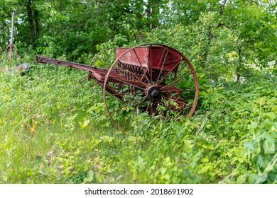 Old Forgotten Rusting Antique Farm Equipment Left In An Overgrown Meadow, Quebec, Canada.