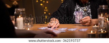 Old fortune teller is dealing cards 