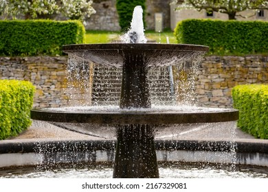 Old fountain in the renovated historic gardens of Dalheim monastery “Kloster Dalheim“ in Lichtenau near Paderborn Germany. Sprinkeling well with perfect symmetry on a sunny springtime day.