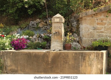 Old French Village Fountain With Flower Bed