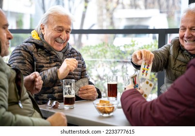 Old friends having fun at cafe - Happy men playing cards together - People sitting at table   - Powered by Shutterstock