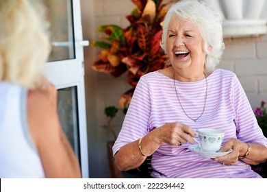 Old friends laughing together and having tea