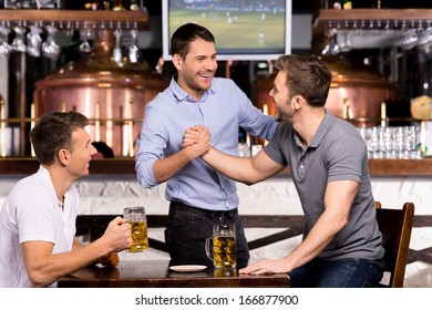 Old Friends Meeting. Three Cheerful Friends Meet Each Other In Beer Pub