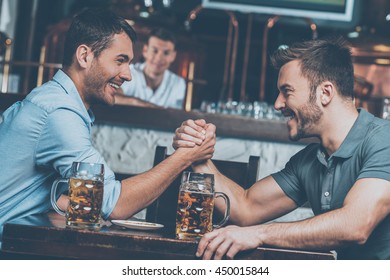 Old friends meeting. Two cheerful young men drinking beer and having fun in bar - Powered by Shutterstock