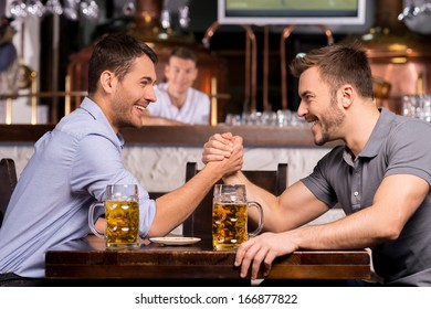 Old friends. Two cheerful young men drinking beer and having fun in bar