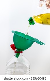 Old Frying Oil Pouring Into Another Bottle With A Green Funnel