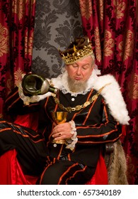 Old Funny King Getting Drunk Holding A Golden Goblet