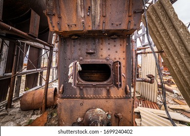 An Old Furnace Sits In The Middle Of The Remnants Of An Airplane Hanger. Military Base In Greenland. 