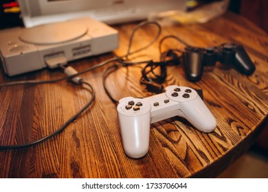 Old Game Joysticks And A Console On A Wooden Table. An Ancient Computer Game. Game-playing In The Late 90s