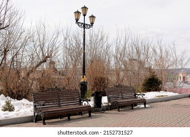 An Old Gas Lantern Near Two Benches And A Trash Can. Park Start , Tomsk, Siberia, Russia.