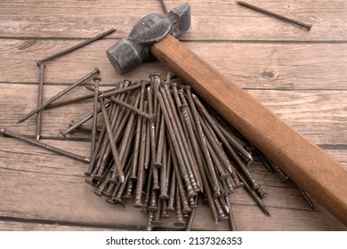 old gavel and pile of old metal nails lie  
 on the wooden table