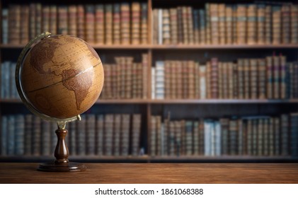 Old geographic globe in the cabinet against the background of bookselfs.Science, education, travel, vintage background. History globe and geography theme.
