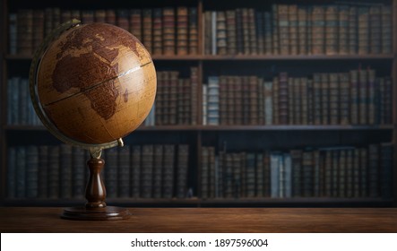 Old geographic globe in the cabinet against the background of bookselfs. Science, education, travel, vintage background. History and geography team.