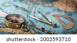 An old geographic map with navigational tools: compass, divider, ruler, protractor. View of the workplace of ship