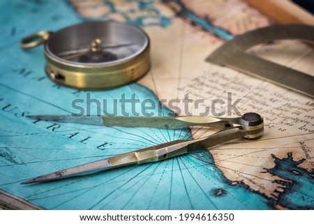 An old geographic map with navigational tools: compass, divider, protractor. View of the workplace of ship's captain. Travel, geography, navigation, tourism, history and exploration concept background