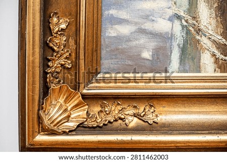 An old gilded frame with a decorative relief in the form of a mushli and oak leaves
