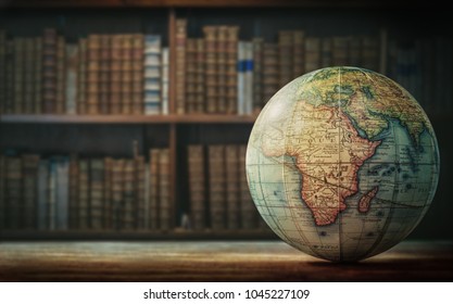 Old globe on bookshelf background. Selective focus. Retro style. Science, education, travel, vintage background. History team. - Shutterstock ID 1045227109