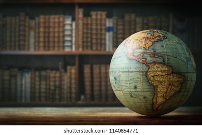 Old globe on bookshelf background. Selective focus. Retro style. Science, education, travel, vintage background. History and geography team.