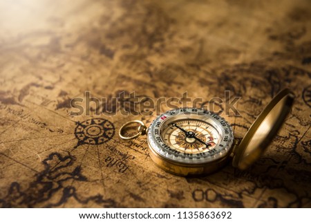 Old gold compass on ancient map background ,vintage tone with copy space for text.