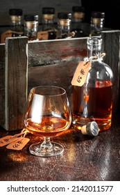 Old And Golden Whisky With Ice In A Glass In The Distillery. Glass Of Whisky With Ice In An Old Cellar.