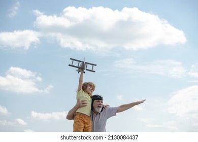 Old Grandfather And Young Child Grandson Having Fun With Plane Outdoor On Sky Background With Copy Space. Child Dreams Of Flying, Happy Childhood With Grand Dad.