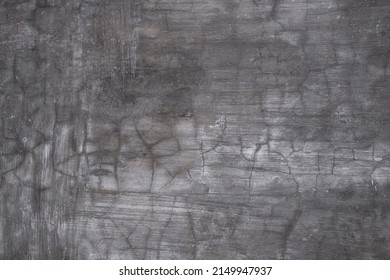 Old gray cement wall with deep crevices and cracks