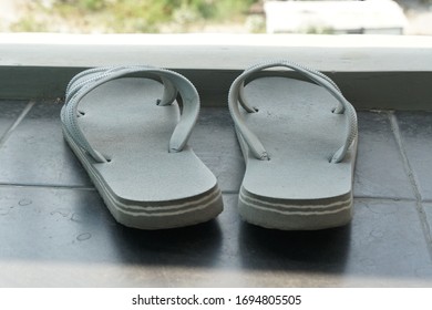 Old gray flip flops on the balcony