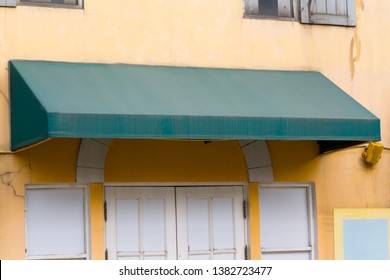 Old Green Awning Over The Entrance Door With Blank White Sign.