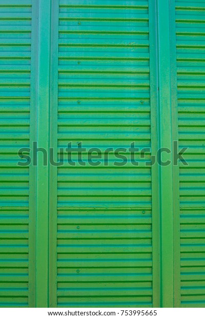 Old\
green background. Metal door wooden freight car. The texture of the\
train car. Stamped metal surface is dark\
green\
