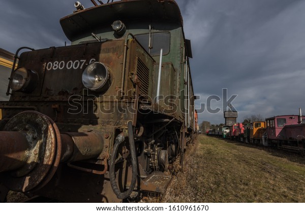 Old green locomotive\
on a train cemetery