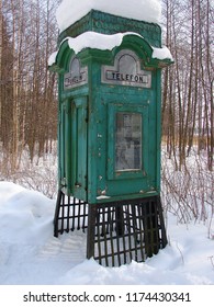 Old Green Telephone Box In Forest Under Snow