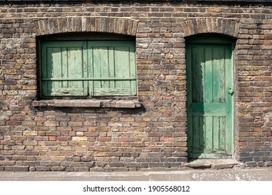 Old Green wooden door and window with wooden shutters on victorian building
