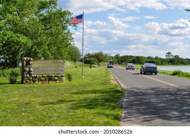 Old Greenwich, CT, USA-August 2020: View of the entrance of Greenwich Point Park or Tods Point with large sign next to road and American flag