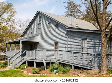 An Old Grey Wood Siding House With A Wheelchair Accessible Ramp